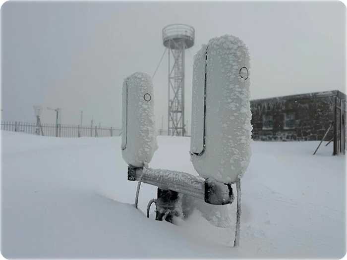 Télescopes Vespera de Vaonis entièrement givrés, tour de l'observatoire en arrière-plan sous la neige